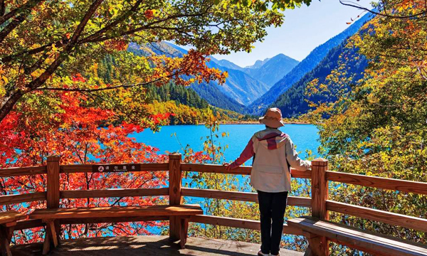 Traveler enjoying the autumn scenery of Jiuzhaigou Valley
