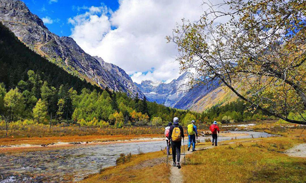 Hikers trekking through Changping Valley in Mount Siguniang