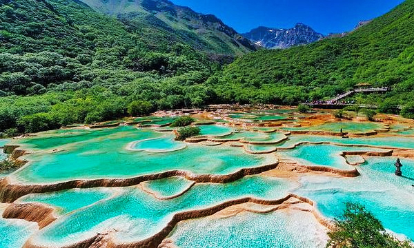 turquoise travertine pools surrounded by mountains in Huanglong Scenic Area