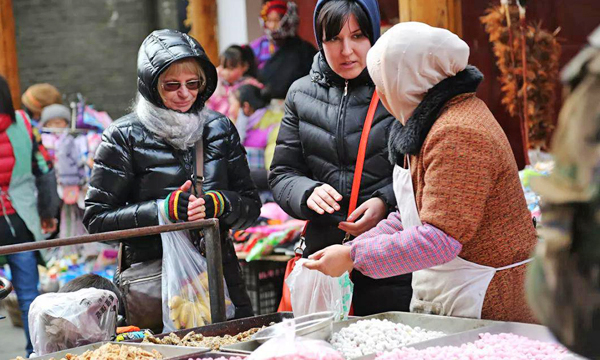 Travelers shopping at a local market in Songpan Ancient Town