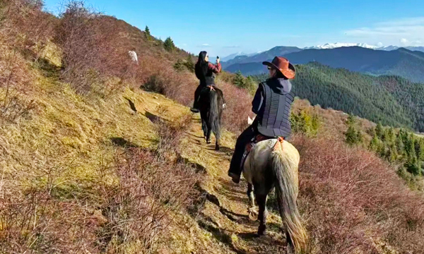 Traveler horse trekking on a mountain trail near Songpan
