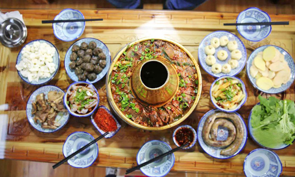 yak meat hotpot with side dishes and dipping sauces in Songpan