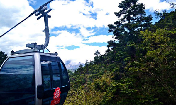 Taking the cable car to climbing the mountain in Huanglong Park