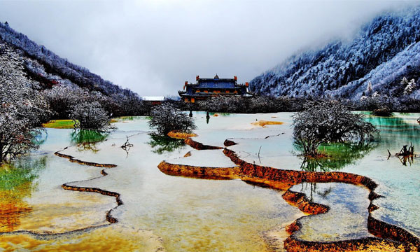 Huanglong National Park is surrounded by sonw-capped mountain and forest in low reason