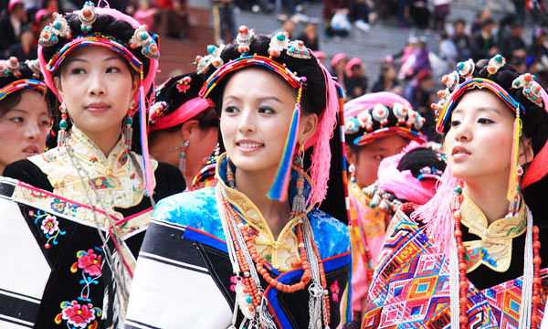 Women clad in colorful, hand-woven belts and clothes.